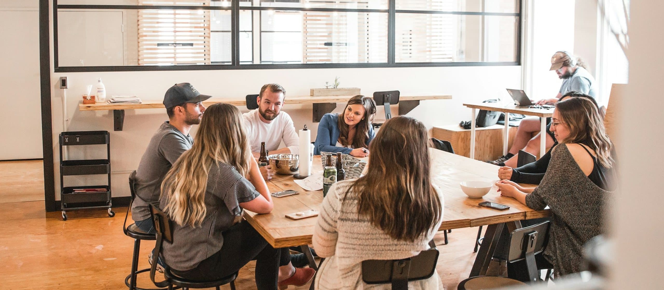 A team talking around a shared table in a bright office