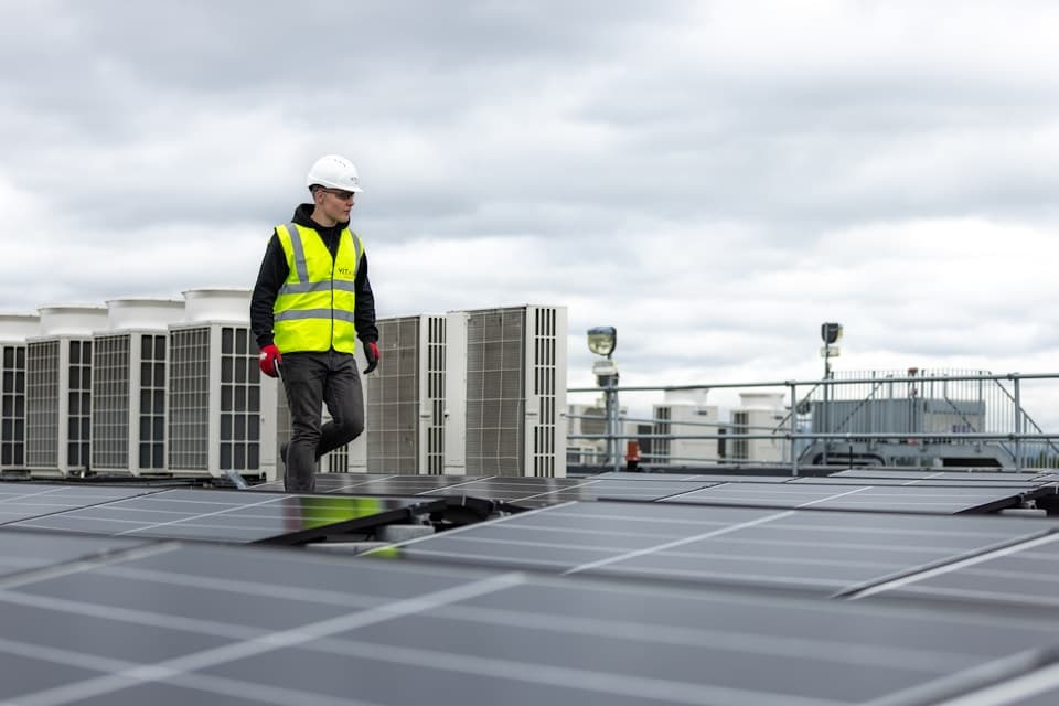 An engineer walking across a rooftop solar array